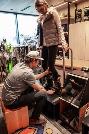 An expert boot fitter at the Mudroom helping a woman get the perfect ski boot fit at Jackson Hole Resort.